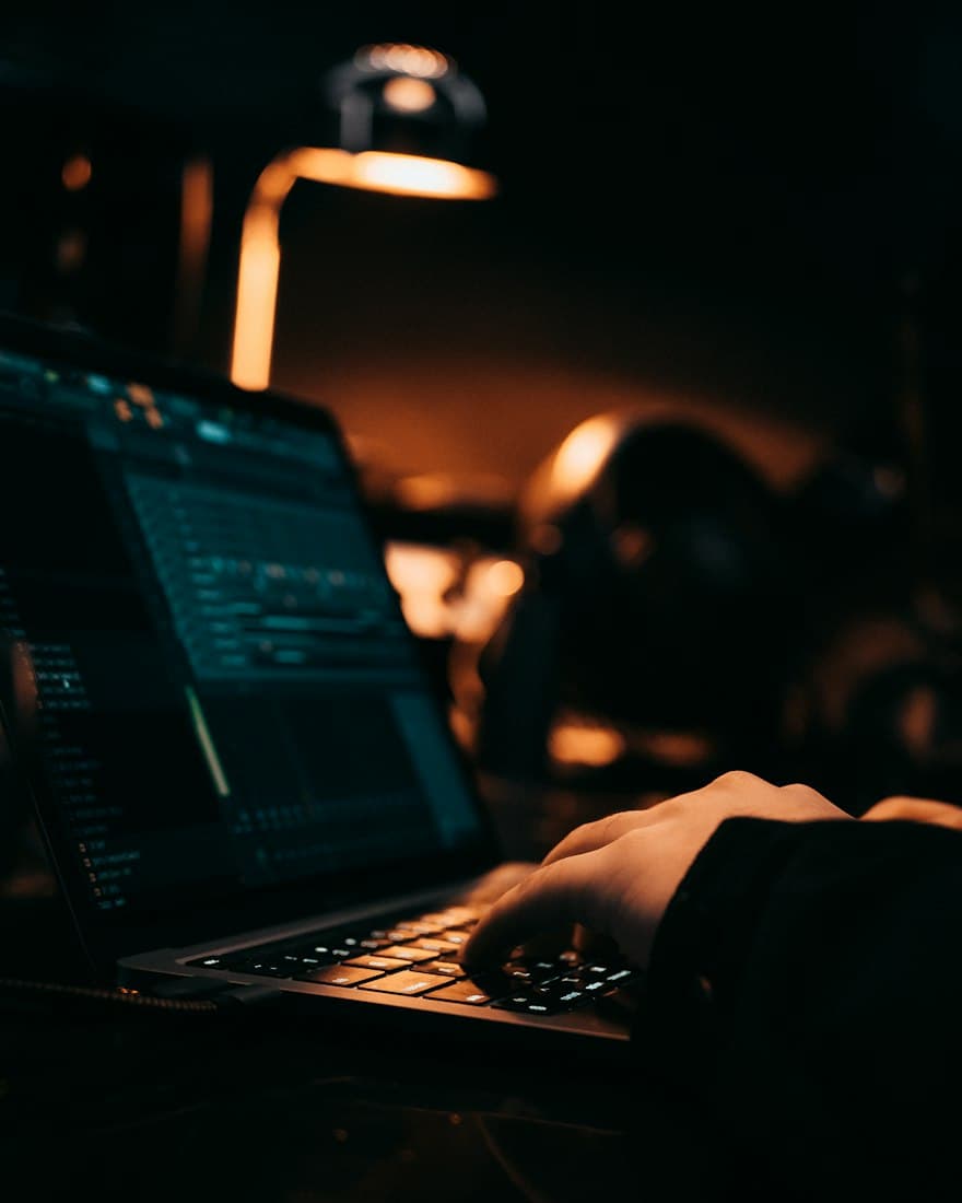 Someone typing on a laptop in a dark room