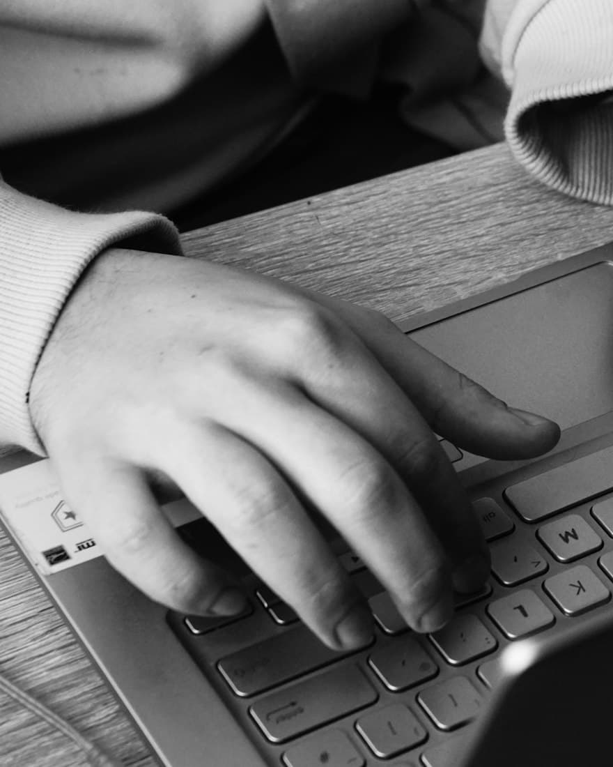 Hands typing on a laptop keyboard