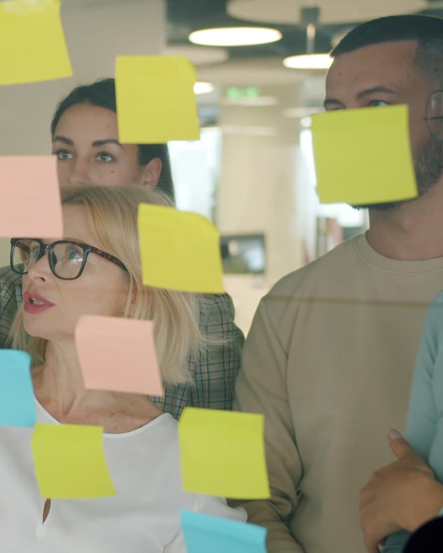 A team brainstorming with sticky notes on a glass wall