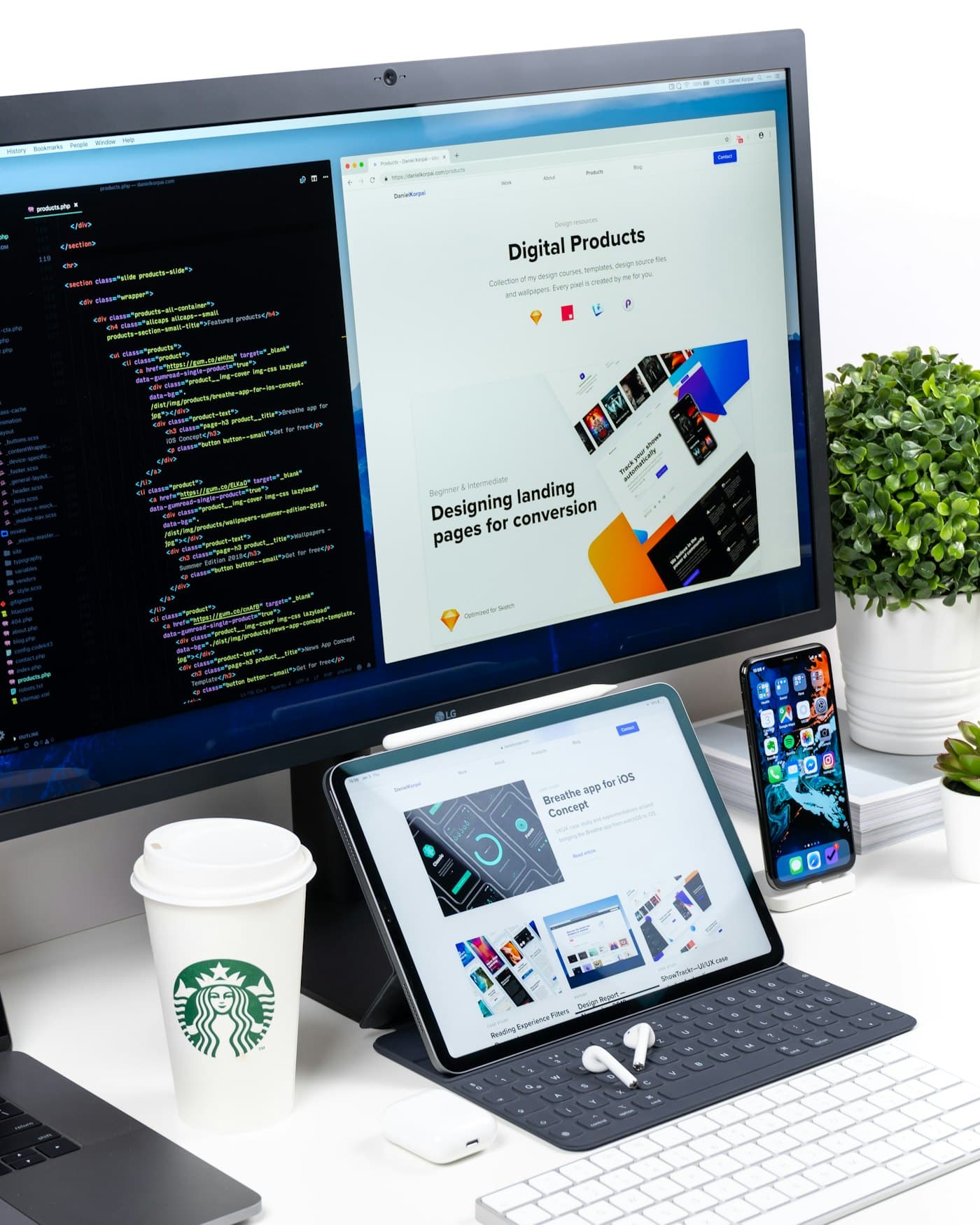 A website design and its code on a desktop monitor, with the same site on a tablet and phone